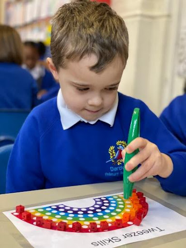 A Dartford Primary pupil is seen sitting at a desk, playing an independent board game.