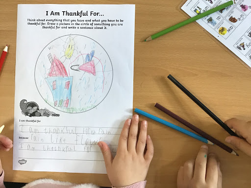 A photo taken from above showing a worksheet completed by a young pupil, titled 'I Am Thankful For...'.