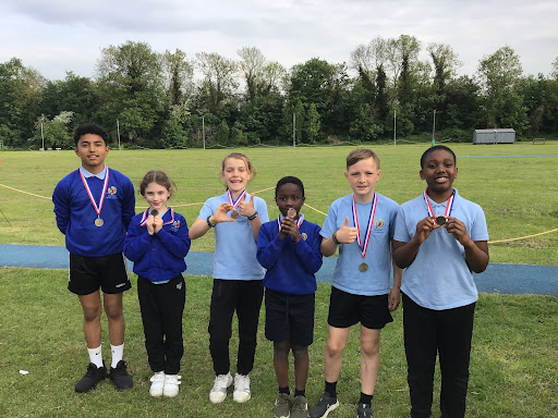 A group of six Dartford pupils are seen smiling for the camera and wearing their medals around their necks during the Dartford District Athletics competition.