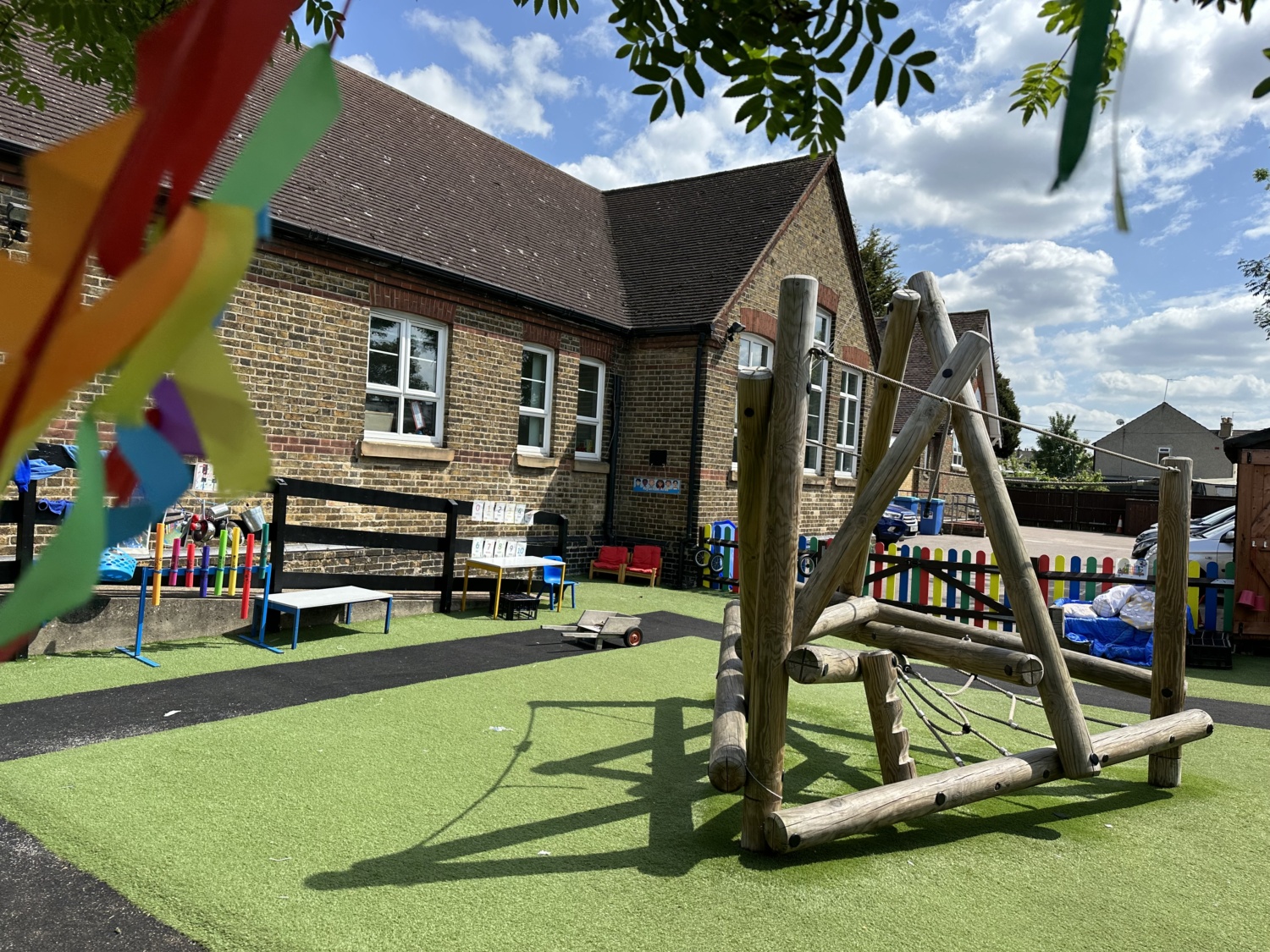 An image of the outdoor play area, with benches and a climbing frame