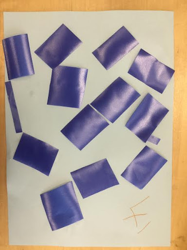 Some blue coloured paper rectangles are shown placed on top of a sheet of white paper.
