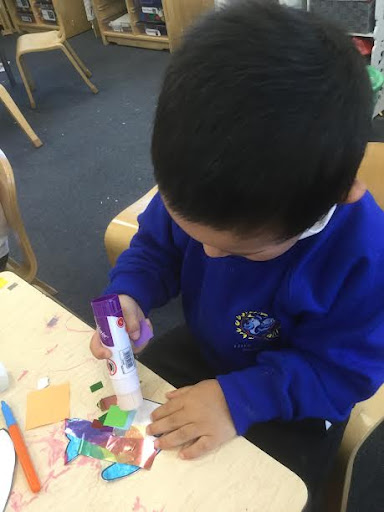 Nursery pupils are pictured creating artwork inspired by the story of 'The Rainbow Fish'.