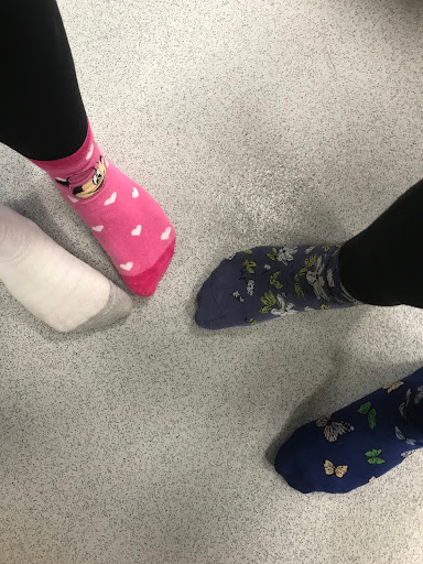 Two girls show off the odd socks they have worn to the camera in support of Anti-Bullying Week.