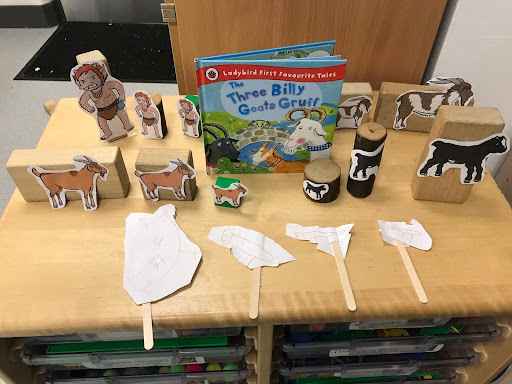 Front cover of the book 'The Three Billy Goats Gruff' shown on a desk alongside some animal figurines and puppets.