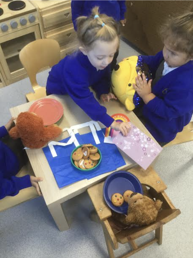 Students playing with bears around a table