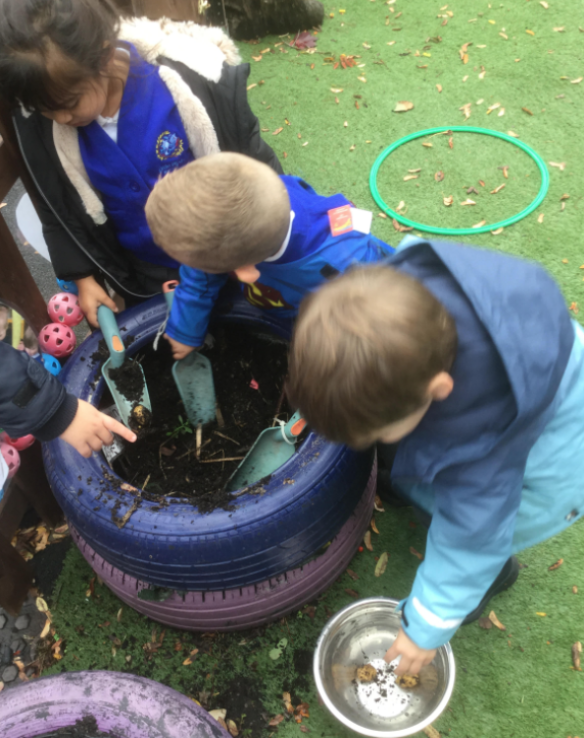 Three Nursery students seen potting plants inside a tyre on the academy grounds.