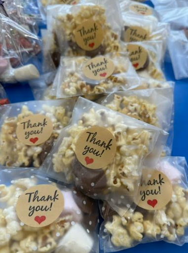 A photo showing some bags of popcorn laid out across a table, ready to be sold by Dartford Primary pupils to other pupils.