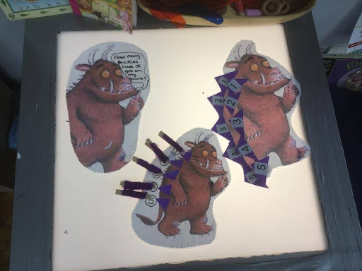 Some pictures of the children's storybook character 'The Gruffalo' are seen placed on top of a lightbox in a classroom in the Nursery.