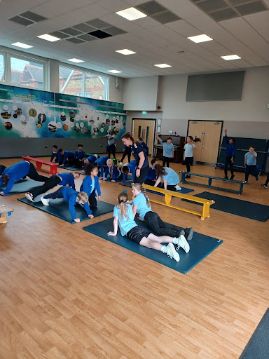 Students at DPA are pictured participating in a Gymnastics exercise, under the supervision of a professional athlete visiting the academy for Sports for Champions Day.