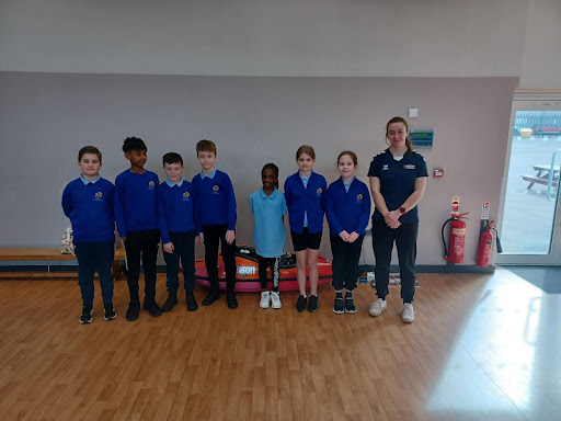 A group of DPA students are pictured smiling for the camera in their academy uniform, alongside a professional athlete visiting the school on Sports for Champions Day.