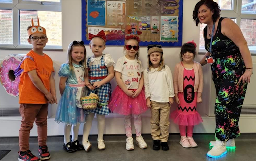 A group of DPA students are pictured smiling for the camera, alongside their class teacher, whilst wearing their fancy dress outfits on World Book Day 2024.