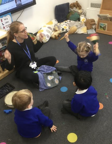 Students learning on the floor with a staff member